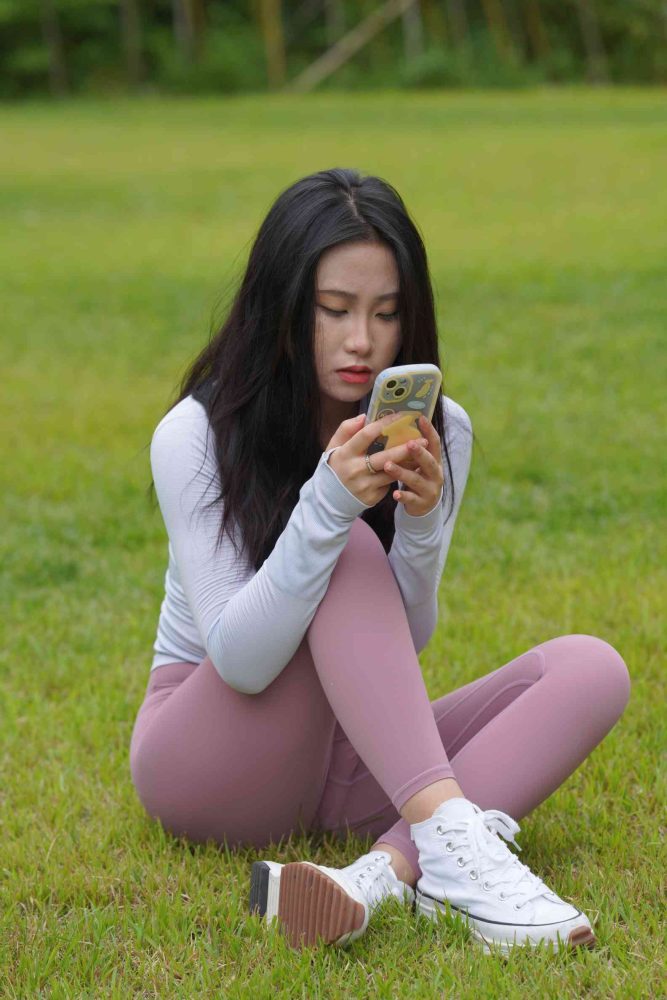 图片[1]-坐在草地玩手机的瑜伽姑娘【733P】04012-知图屋